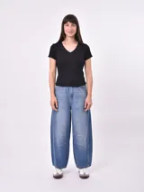 Remera blanca de punto con cuello en V y mangas cortas con volados.