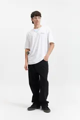 Pantalón de jean negro, corte amplio y ancho en piernas y cadera, tiro medio y presillas para cinturón.