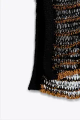 Vestido midi de punto calado con rayas horizontales en tonos negro y dorado, escote en V, manga corta y aberturas laterales en el ruedo.