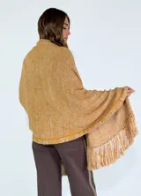 Chaleco tipo pashmina tejido en color blanco con detalles plateados y flecos en el borde inferior.