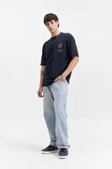 Remera azul marino de manga corta con textura y fit oversize. Presenta un pequeño bordado en relieve en el pecho.