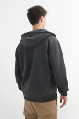Campera negra con capucha, cierre frontal y bolsillos tipo canguro.