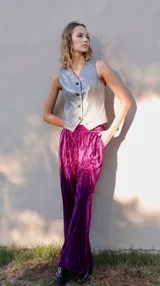 Pantalón de terciopelo color fucsia, de corte amplio con elástico en la cintura, bolsillos laterales y pinzas frontales.