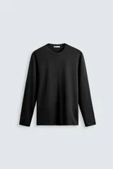 Camiseta negra de manga larga, corte slim fit y cuello redondo.