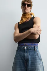 Musculosa blanca de algodón con cuello redondo y sisas amplias, corte ajustado.