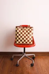 Bolso tipo tote de cuero tejido a mano con diseño a cuadros en color negro y tostado.