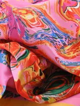 Pañuelo cuadrado de seda color rosa con estampado abstracto multicolor y borde amarillo.