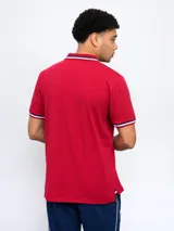 Remera polo azul con cierre, puños y cuello con detalle tricolor. Incluye logo de Umbro y escudo del Club Nacional de Football.