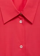 Camisa roja oversize de algodón con cuello camisero, manga larga abotonada, bolsillo de parche en el pecho y cierre frontal con botones.