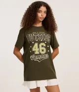 Remera verde militar de algodón con cuello redondo y mangas cortas. Estampa frontal con la frase "Open to Visitors Outside 46 Campus" en color blanco y verde claro, con estrellas decorativas.