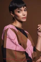 Aros dorados con detalle de esmalte negro en forma de corazón.