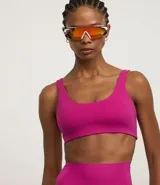 Top deportivo de microfibra color fucsia, con tirantes anchos fijos y copa incorporada.