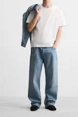 Pantalón de jean celeste con efecto lavado, corte amplio tipo baggy y cinco bolsillos.