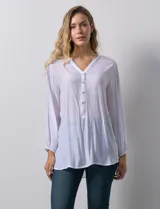 Blusa blanca de manga larga con cuello a la base y escote en V con botones. Terminación de manga con elástico.