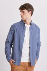 Camisa celeste de micropana con cuello abotonado, manga larga y bolsillo en el pecho.