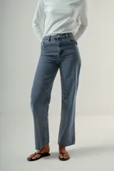 Pantalón de denim azul claro, tiro alto, de corte recto y pierna ancha. Presenta detalles bordados en el área de los bolsillos delanteros y traseros.