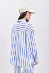 Camisa celeste y blanca a rayas verticales, de corte holgado y manga larga.