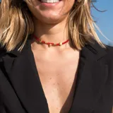 Collar estilo choker con cristalitos rojos y dijes dorados de conchas y estrellas.