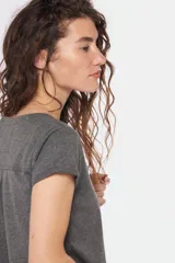 Remera color beige con escote redondo, manga corta, bolsillo en el pecho y cierre parcial con botones.