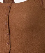 Musculosa marrón de poliéster texturizado, con escote cuadrado, breteles anchos, abotonado delantero y abertura inferior.