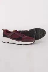 Zapatilla deportiva urbana de hombre, con suela de goma y textil de 100% algodón, diseño en tonos burdeos y negro.