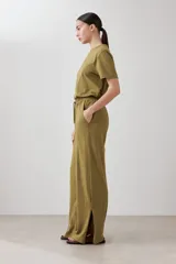 Pantalón verde oliva de corte palazzo con pretina elastizada y cordón ajustable. Incluye bolsillos laterales.