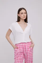 Blusa blanca con escote en V y mangas cortas.