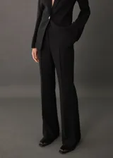 Pantalón negro de vestir, corte wideleg, tiro medio y cintura elástica.