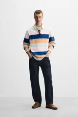 Polo de manga larga con cuello clásico y cierre de botones oculto. Diseño a rayas horizontales en colores azul, naranja, rosa y verde.