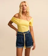 Short baggy de jeans azul oscuro, con cintura alta, trabillas, bolsillos y ruedo doblado. Incluye cinturón de cordón color crudo con borlas.