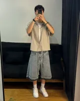 Bermuda de jean celeste matizado, corte baggy, con cordón ajustable en la cintura y detalle artesanal visible en el bajo.