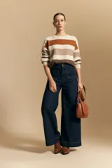 Jean de corte wide leg y tiro alto, confeccionado en denim azul oscuro con costuras a contratono. Presenta bolsillos frontales tipo parche y una silueta amplia que aporta una caída estructurada.