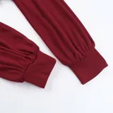 Top corto rojo con escote off-shoulder y mangas largas abullonadas.