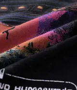 Remera regular de algodón color negro con estampado frontal de un ovni y la frase "Space Cats Invaders" en tonos rosados y morados.