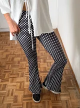 Calza larga de lycra negra con lunares blancos.