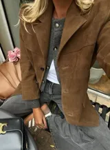 Blazer marrón de gamuza con solapas de muesca, cierre cruzado con botones y bolsillos delanteros con solapa.