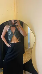 Top halter de cuero negro con apliques plateados y flor de cuero plateada.