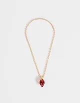 Cadena dorada con dije de frutilla transparente con incrustaciones plateadas.