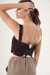 Top corto de cuero ovino con estampado de vaca en blanco y negro, de corte recto y breteles anchos.