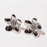 Aros de acero plateado con forma de flor.