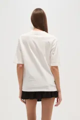 Remera blanca de algodón con tachas plateadas y cuello redondo.