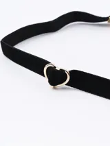Gargantilla choker de terciopelo negro con dije de corazón dorado y cadena de alargue dorada.