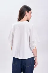 Remera blanca de algodón con mangas cortas y detalle de broderie calada en los bordes.
