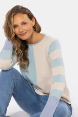 Buzo de tejido fino con diseño de bloques de color en beige, rosado y azul, y mangas con rayas horizontales en beige y rosado. Confeccionado en algodón, de manga larga y cuello redondo.