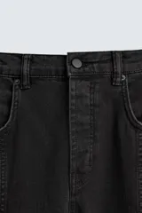 Pantalón relaxed fit confeccionado en denim de algodón color negro. Cuenta con bolsillos frontales, traseros de plastrón y bolsillos multifunción en las perneras. Tiene efecto lavado y cierre frontal con cremallera y botón.
