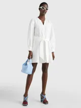 Vestido blanco de algodón orgánico con cuello V, cierre de botones y cinta ajustable en la cintura.