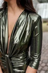 Vestido verde metalizado con escote en V pronunciado, mangas 3/4 y frunce en la cintura.