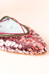 Bailarinas chatitas con punta cubierta de lentejuelas rosadas, laterales y talón de gamuza verde oliva, y tobillera de cuero con estampado animal print. Se atan al tobillo con cordones rosas y tienen un pequeño fleco decorativo en el talón.