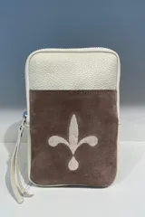 Cartera pequeña tipo pocket bag de cuero color negro, con cierre superior y correa de muñeca. Presenta un aplique de cuero marrón con el dibujo de una flor de lis.