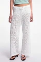 Pantalón blanco de tejido calado con cintura elástica y cordón ajustable.